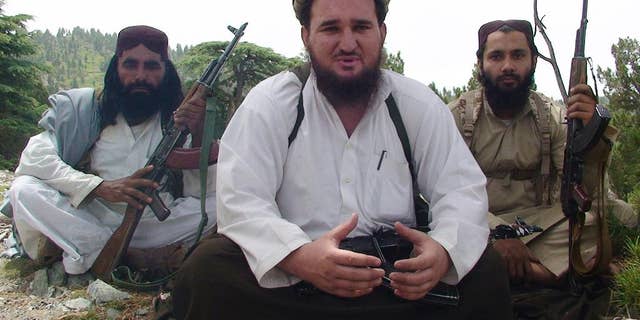 FILE -- In this Aug. 6, 2012 file photo, Ahsanullah Ahsan, center, talks to The Associated Press in the militant group's stronghold of Shawal, in the Pakistani tribal region of South Waziristan. Pakistani authorities are questioning Ahsan, a senior militant who they say voluntarily surrendered, presenting it as a major setback for an Islamic extremist group that has carried out several major attacks. Military officials confirmed Tuesday, April 18, 2017, that Ahsanullah Ahsan, a former spokesman and senior figure in the Jamaat-ul-Ahrar group, had surrendered recently. (AP Photo/Ishtiaq Mahsud, File)