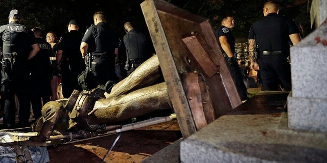 Police stand guard after “Silent Sam” was toppled by protesters on campus at the University of North Carolina in Chapel Hill, N.C.