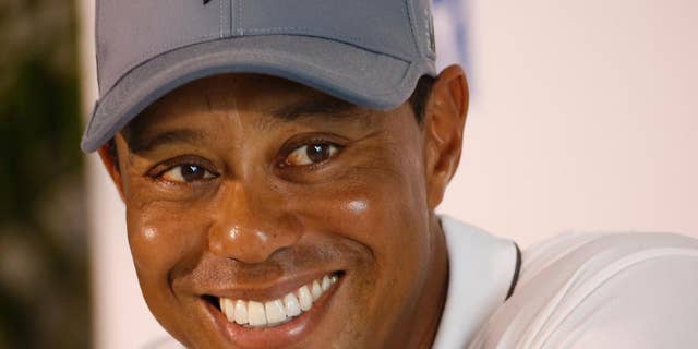 In this July 28, 2015, file photo, Tiger Woods smiles as he answers a question during a news conference prior to the start of the Quicken Loans National golf tournament, in Gainesville, Va.  Tiger Woods says he hopes to play next month in the PGA's Safeway Open in Napa, Calif., his first competitive golf since August 2015. 