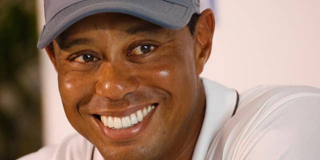 In this July 28, 2015, file photo, Tiger Woods smiles as he answers a question during a news conference prior to the start of the Quicken Loans National golf tournament, in Gainesville, Va. Tiger Woods says he hopes to play next month in the PGA's Safeway Open in Napa, Calif., his first competitive golf since August 2015.