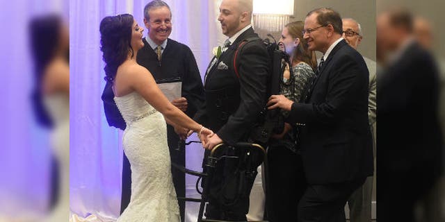 Jordan Basile, left, and Matt Ficarra, center, exchange wedding vows Saturday, Oct. 18, 2014, at the Doubletree hotel in Syracuse, N.Y. (AP Photo/The Syracuse Newspapers, Dennis Nett)