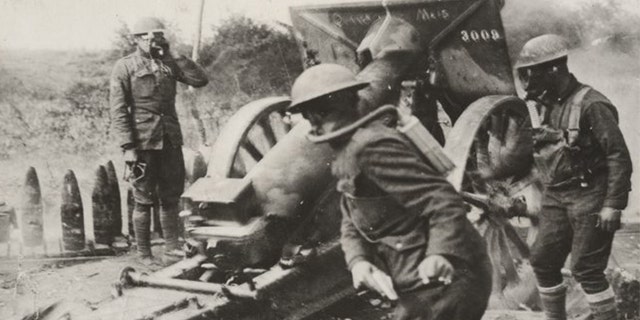 American soldiers in the Army’s 108th Field Artillery – under fire from enemy gas shells – strike back in Varennes-en-Argonne, France.