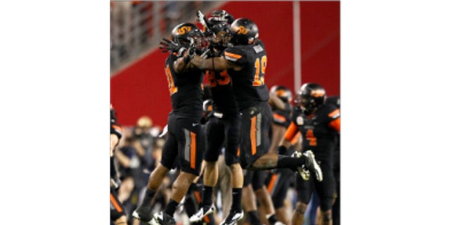 Oklahoma State cornerback Brodrick Brown (19), Colton Chelf, center, and Shaun Lewis, right, celebrate a missed field goal attempt by Stanford during overtime of the Fiesta Bowl NCAA college football game Monday, Jan. 2, 2012, in Glendale, Ariz.