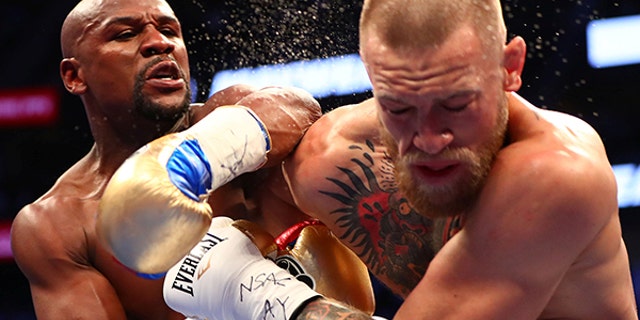 Floyd Mayweather Jr. lands a punch against Conor McGregor during their boxing match in Las Vegas, August 26.