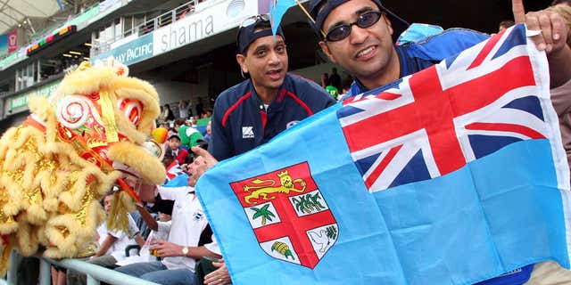 March 18, 2005: Rugby fans hold a Fiji national flag during the Rugby World Cup Sevens in Hong Kong.