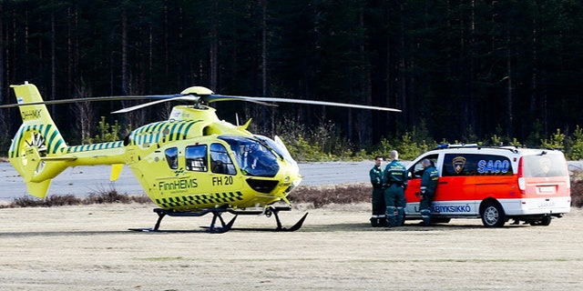 April 20, 2014: A helicopter and an ambulance are seen at the Jamijarvi Airfield, southwest Finland. A small passenger plane carrying parachuters fell to the ground near the airfield on Sunday afternoon. The police say that there are more than three victims. Three people out of 11 on the plane were rescued.
