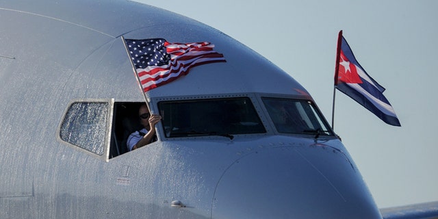 TOPSHOT - An American Airlines plane fluttering US and Cuba national flags is seen uppon arrival at Jose Marti International Airport becoming the first Miami-Havana commercial flight in 50 years, coinciding with the beginning of the tributes to late Cuban leader Fidel Castro, on November 28, 2016 in Havana. / AFP / YAMIL LAGE (Photo credit should read YAMIL LAGE/AFP/Getty Images)