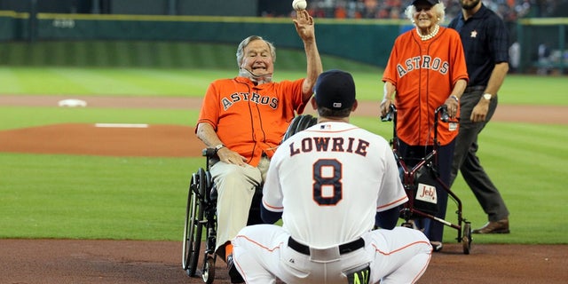 Former President George H.W. Bush throws out the ceremonial first pitch to the Houston Astros in a game against the Kansas City Royals in 2015.