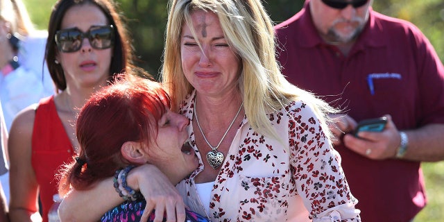 Parents wait for news after a reports of a shooting at Marjory Stoneman Douglas High School in Parkland, Fla., on Wednesday, Feb. 14, 2018.