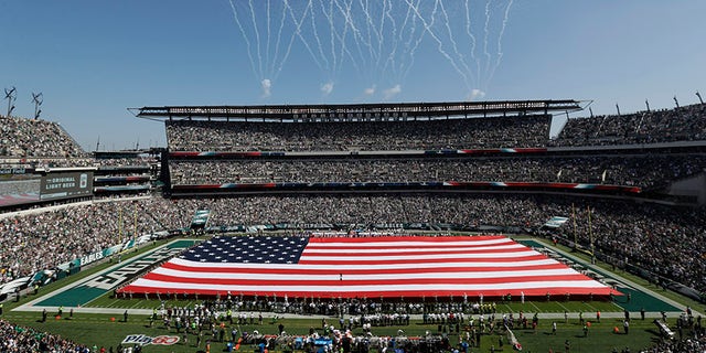 An American flag covers the field before an NFL game between the Philadelphia Eagles and the New York Giants in Philadelphia.