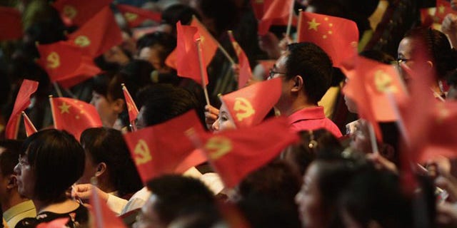 People wave flags of China's Communist Party at a celebration of the Communist Party's 90th anniversary in Chongqing municipality July 1.