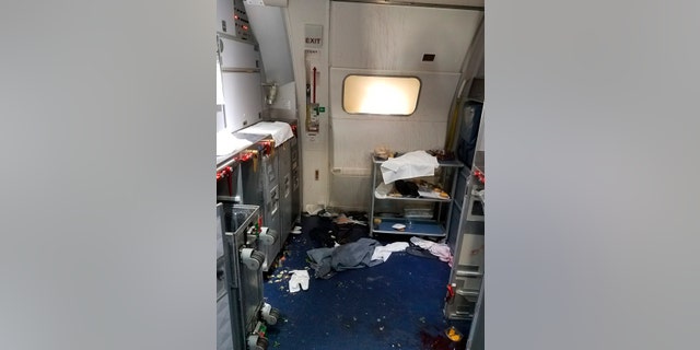 This Friday, July 7, 2017 photo taken the FBI and released via the U.S. Attorney's Office in Seattle shows the aftermath of a cabin on Delta Flight 129 from Seattle to Beijing, after authorities say flight attendants struggled with Joseph Daniel Hudek IV, a passenger who lunged for an exit door. The photo was included in a criminal complaint filed Friday, July 7. The passenger is charged with interfering with a flight crew and faces up to 20 years in prison. (FBI via U.S. Attorney's Office in Seattle via AP)