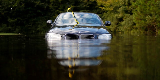 FILE- In this Tuesday, Sept. 18, 2018, file photo a car sits in a flooded parking lot at an apartment complex near the Cape Fear River as it continues to rise in the aftermath of Hurricane Florence in Fayetteville, N.C. As flooding continues in the Carolinas after Florenceâs massive rainfall, experts say high water will damage thousands of vehicles. (AP Photo/David Goldman, File)
