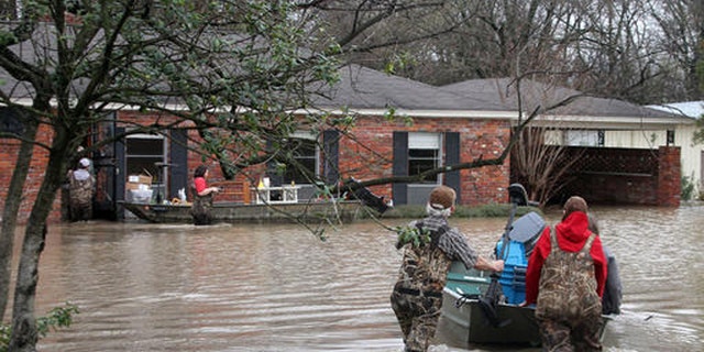 Volunteers return to a flooded house in Clarksdale, Miss., Friday, March 11, 2016. (Troy Catchings/The Clarksdale Press Register, via AP)