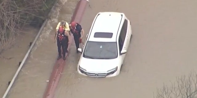 Authorities rescue a driver from floodwaters in North Texas.