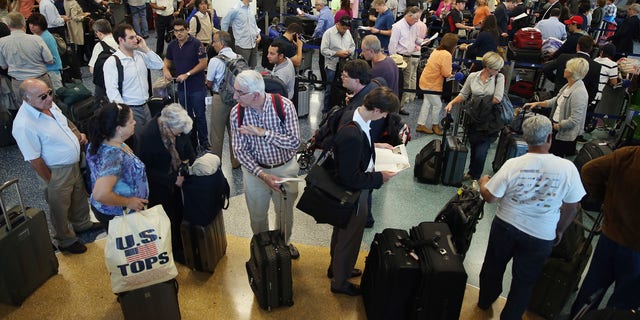 Passengers wait in line at Miami International Airport on April 16, 2013 in Miami, Florida. (Photo by Joe Raedle/Getty Images)