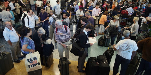 Passengers wait in line at Miami International Airport on April 16, 2013 in Miami, Florida. (Photo by Joe Raedle/Getty Images)