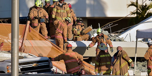 First responders inspect the damage after a pedestrian bridge collapsed near Florida International University in Miami.