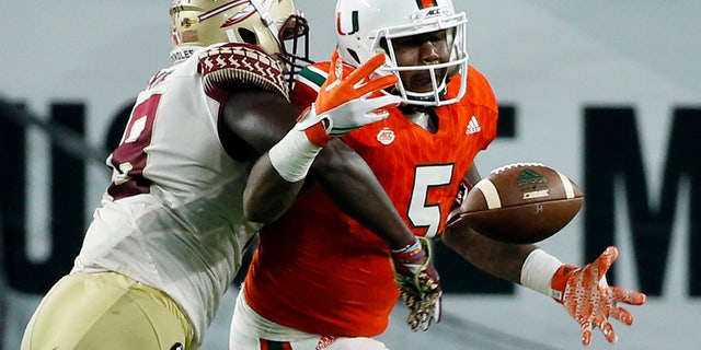 Miami Hurricanes tight end Standish Dobard (5) can't hold on to the ball as Florida State linebacker Ro'Derrick Hoskins (18) defends during the second half of an NCAA college football game, Saturday, Oct. 8, 2016, in Miami Gardens. (AP Photo/Wilfredo Lee)