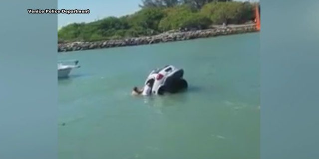 In a clip from video, bystanders try to rescue a father and daughter from a sinking van in the Venice Inlet in Florida.