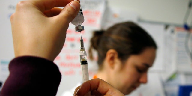 Nurses prepare influenza vaccine injections during a flu shot clinic at Dorchester House, a health care clinic, in Boston, Massachusetts.