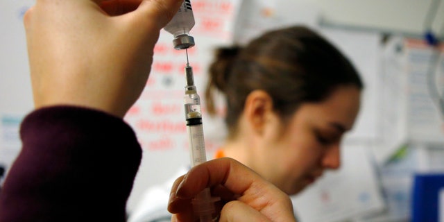Nurses prepare influenza vaccine injections during a flu shot clinic at Dorchester House, a health care clinic, in Boston, Massachusetts.
