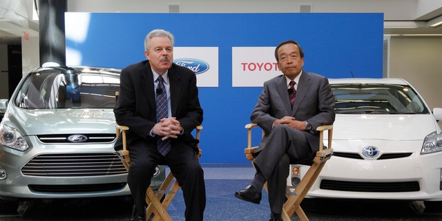 Derrick Kuzak, Ford Motor Company group vice president, Global Product Development, left, and Takeshi Uchiyamada, Toyota Motor Corporation executive vice president, Research &amp; Development shake hands at a news conference in Dearborn, Mich., Monday, Aug. 22, 2011. The automakers announced they will equally collaborate on the development of an advanced new hybrid System for light truck and SUV customers.  (AP Photo/Paul Sancya)