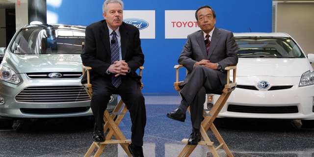 Derrick Kuzak, Ford Motor Company group vice president, Global Product Development, left, and Takeshi Uchiyamada, Toyota Motor Corporation executive vice president, Research & Development shake hands at a news conference in Dearborn, Mich., Monday, Aug. 22, 2011. The automakers announced they will equally collaborate on the development of an advanced new hybrid System for light truck and SUV customers. (AP Photo/Paul Sancya)