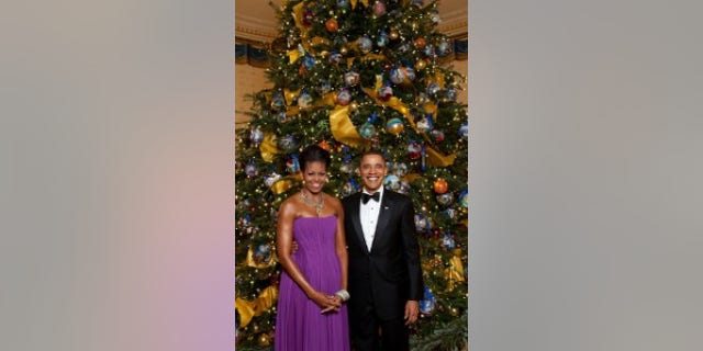 President Barack Obama and First Lady Michelle Obama pose for a formal portrait in front of the official White House Christmas Tree in the Blue Room of the White House, Dec. 6, 2009. (Official White House Photo by Lawrence Jackson)