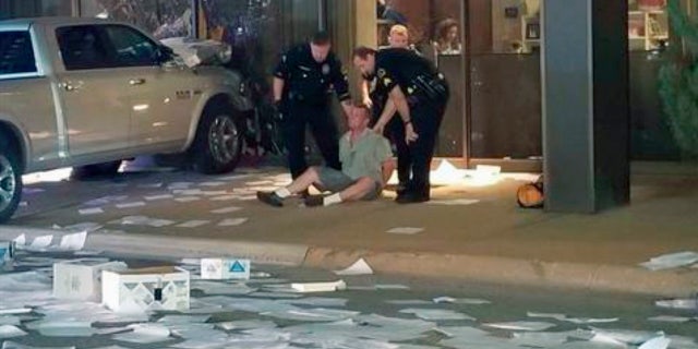 In this image taken from video by Fox 4, Michael Chadwick Fry is detained after crashing his pickup truck into the side of the Fox affiliate television station building in downtown Dallas.