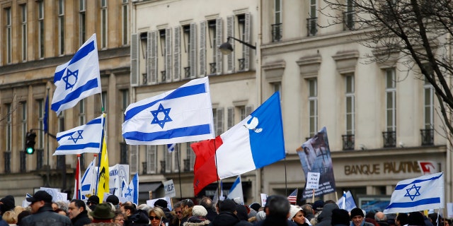 Pro-Israel demonstrators hold Isreali and France flags during a gathering in front of Israel embassy in Paris, France, Sunday, Jan. 15, 2017.