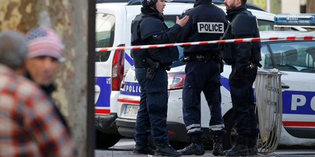 Jan. 7, 2016: Police officers secure the area after a fatal shooting took place at a police station in Paris.