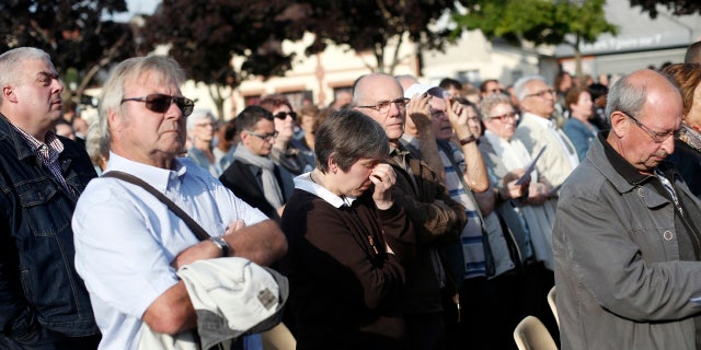 People attend a ceremony marking the first anniversary of the killing of French Catholic priest Jacques Hamel.