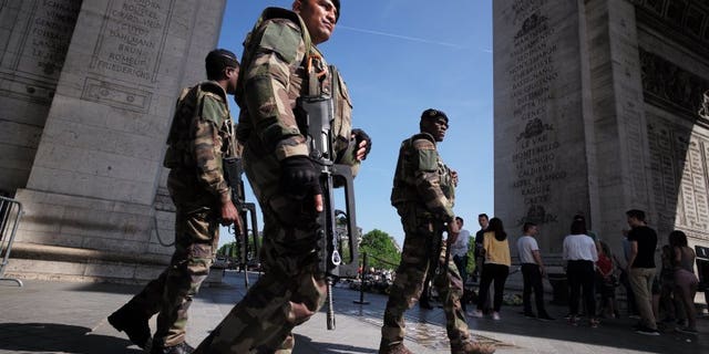 Soldiers near the Eiffel tower in Paris on Thursday, one day before the start of Euro 2016.
