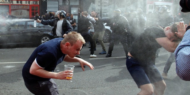 June 15, 2016: English fans run after getting sprayed with pepper spray by French police during scuffles in downtown Lille, northern France.