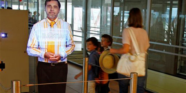 Aug. 18: An airport experimenting "virtual" boarding agent, left, is displayed at Paris' Orly airport, on the southern outskirts of Paris. The pilot project began last month, and has so far been met with a mix of amusement and surprise by travellers, who frequently try to touch and speak with the strikingly life-like video images that greet them and direct them to their boarding gate.
