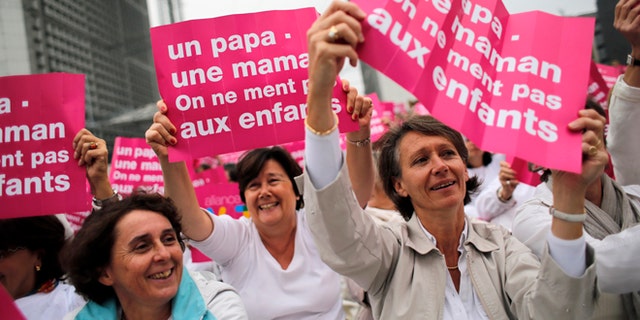 Oct. 23, 2012: In this file photo, anti-gay marriage and gay adoption rights activists hold posters reading: "Mother - Father. Don't lie to your children" demonstrate in Paris. A plan to legalize same-sex marriage and allow gay couples to adopt was a liberal cornerstone of French President Francois Hollande's election manifesto earlier this year.