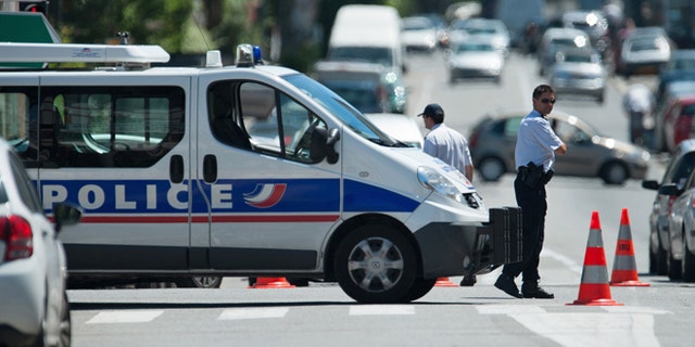 June 20, 2012: Police officers secure the area after a gunman took four people hostage in a bank in the southern French city of Toulouse and fired a shot, police said.