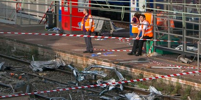 July 13, 2013: Railway's employees look at the scene where a train derailed at a station in Bretigny sur Orge, south of Paris.