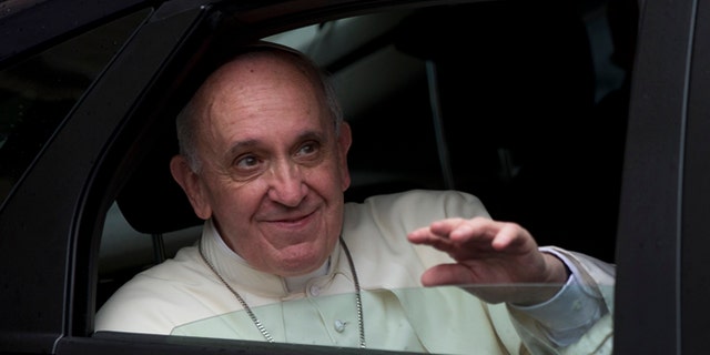 Sept. 10, 2013: Pope Francis waves as he leaves the Astalli Center canteen after his private visit to the Jesuit Service for Refugees organization in Rome. (AP/Alessandra Tarantino)