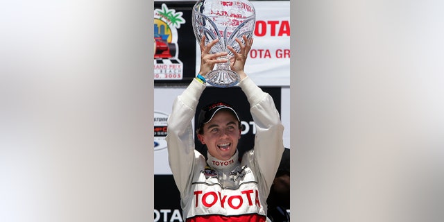 Actor Frankie Muniz sticks out his tongue as he hoists the trophy after winning the 29th Annual Pro/Celebrity Race in Long Beach, California, April 9, 2005.