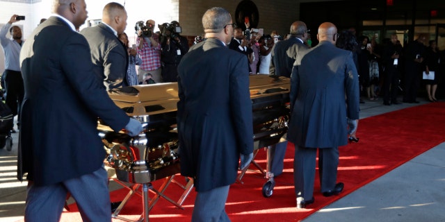 Pallbearers carry the gold casket of legendary singer Aretha Franklin after arriving at the Greater Grace Temple in Detroit, Friday, Aug. 31, 2018. Franklin died Aug. 16 of pancreatic cancer at the age of 76. (AP Photo/Tony Dejak)