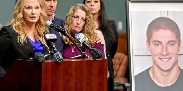 In this May 5, 2017, file photo, Centre County, Pa., District Attorney Stacy Parks Miller, left, announces findings an investigation into the death of Penn State University fraternity pledge Tim Piazza, seen in photo at right, as his parents, Jim and Evelyn Piazza, second and third from left, stand nearby during a news conference in Bellefonte, Pa.