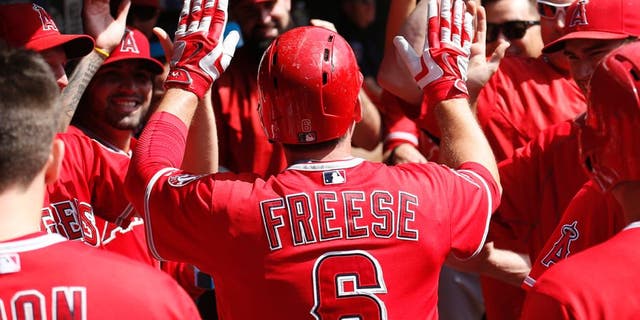 Oct 3, 2015; Arlington, TX, USA; Los Angeles Angels third baseman David Freese (6) celebrates his run with teammates against the Texas Rangers during the fifth inning of a baseball game at Globe Life Park in Arlington. Mandatory Credit: Jim Cowsert-USA TODAY Sports