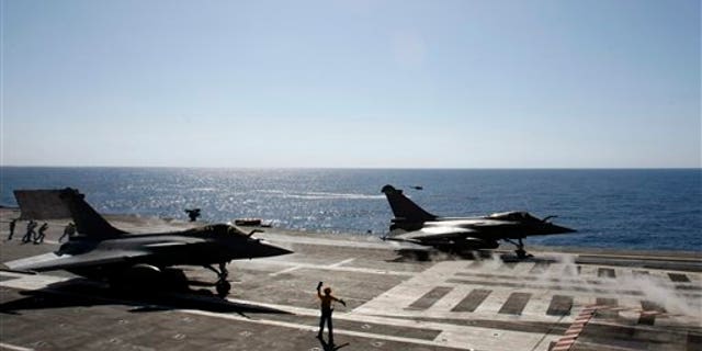 April 12: Rafale fighter jets take off for a mission over Libya to France's flagship Charles de Gaulle aircraft carrier, in the Golf of Sirte, off the Libyan coast. The missions are aimed at enforcing the no-fly zone and supressing any attacks by Gadhafi's forces against civilians and rebels in eastern Libya. (AP)