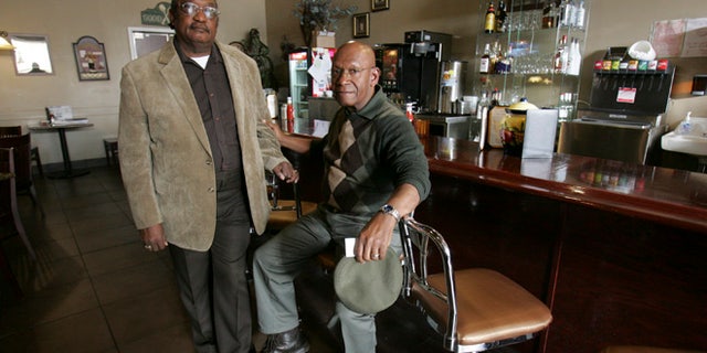 FILE - In this March 5, 2009, file photo, the Rev. W. T. "Dub" Massey, right, and Willie McLeod, left, pose at the counter where they were among the "Friendship Nine" who were jailed during 1960s civil rights "sit-ins" at what is now called the Old Town Bistro in Rock Hill, S.C. A prosecutor on Wednesday, Jan. 28, 2015, is expected to ask a judge to vacate the arrests and convictions of the eight Friendship Junior College students and a civil rights organizer. (AP Photo/Mary Ann Chastain, File)