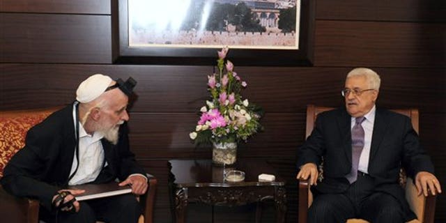 In this photo provided by the Palestinian Authority, Aug. 31, 2011, Palestinian President Mahmoud Abbas, right, sits with Israeli settler leader and peace activist Rabbi Menachem Froman during their meeting in the West Bank city of Ramallah.