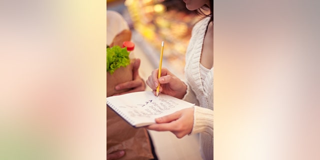 Close-up of shopping list in female hands