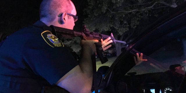 Sept. 16, 2016: A Fort Worth police officer draws his gun at the scene of a shooting that injured two officers.