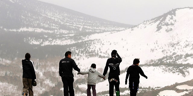 In this photo taken Sunday, May 1, 2011, tourists on the edge of Mt. Azuma-Kofuji's crater in Fukushima, Fukushima Prefecture, northeastern Japan.